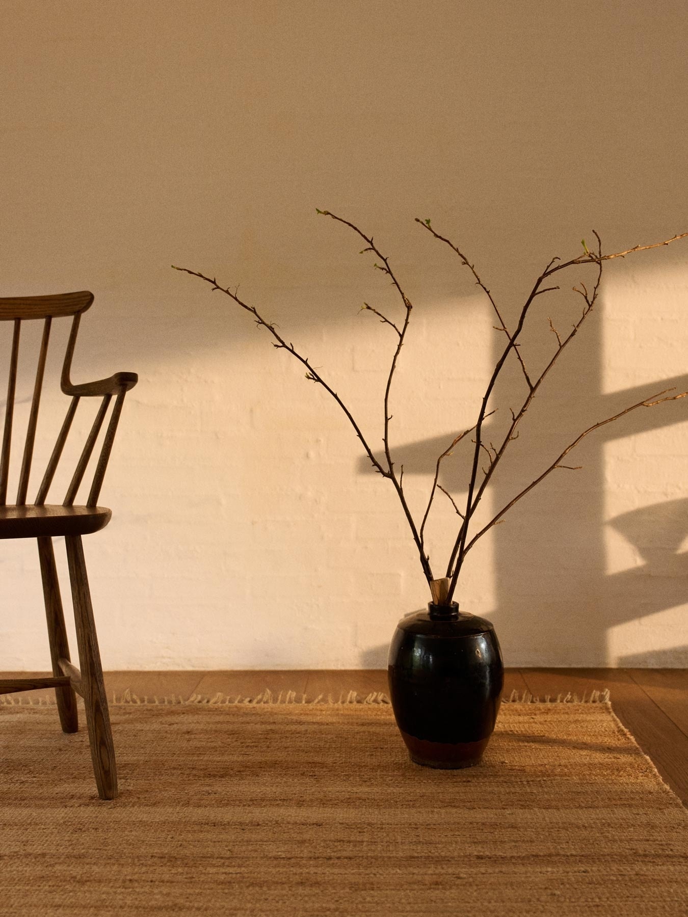 Chair and vase with twig on a large hemp rug