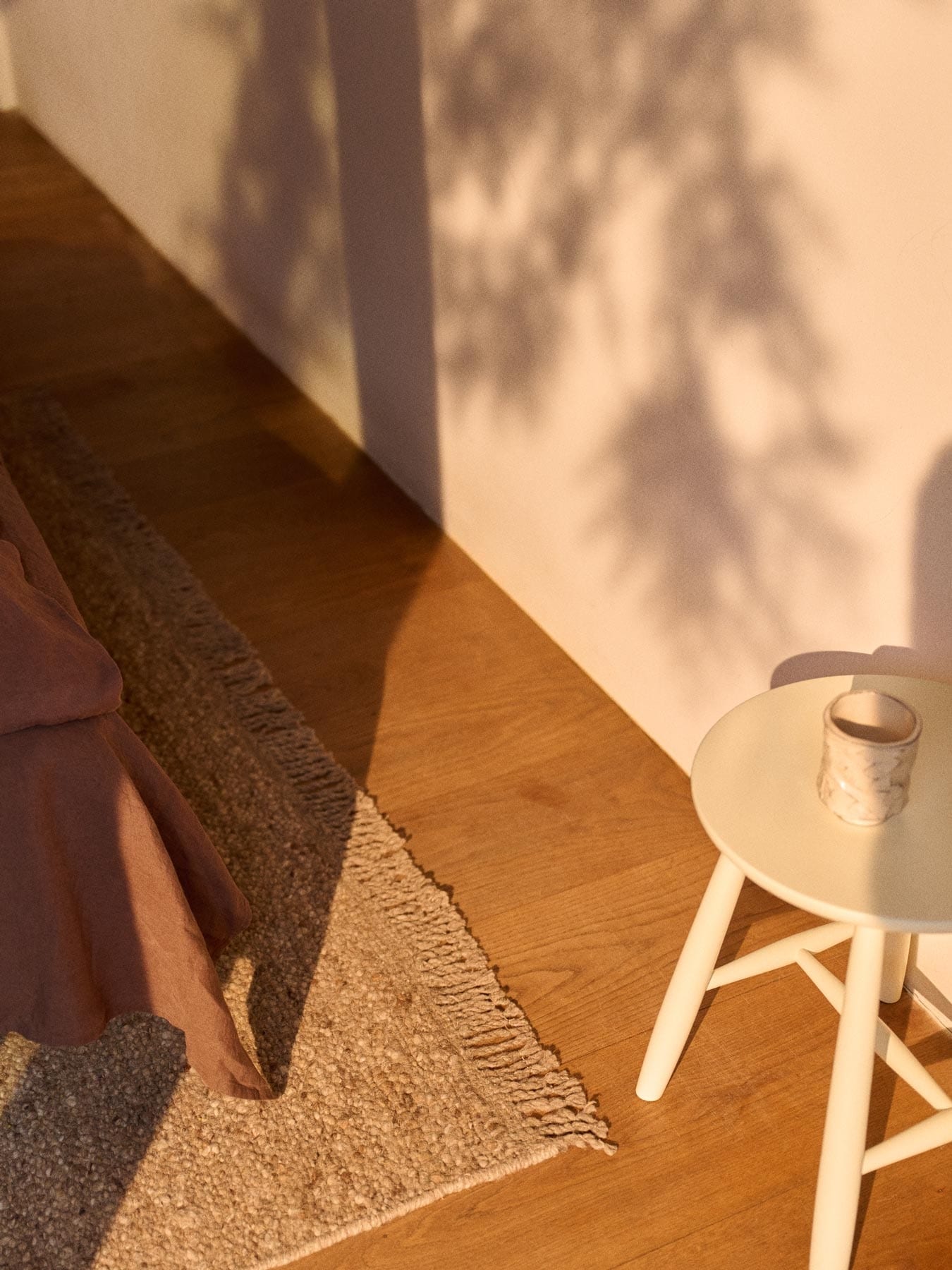 White stool and bed on a rug